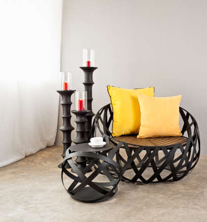 Metal sofa with yellow pillow and candlesの写真素材