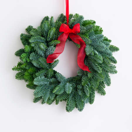 Advent wreath with red ribbon over a bright wallの写真素材