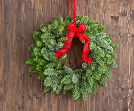 Advent wreath with red ribbon over a brown wooden plankの写真素材