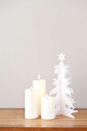 Paper Christmas tree and candles on a side boardの写真素材