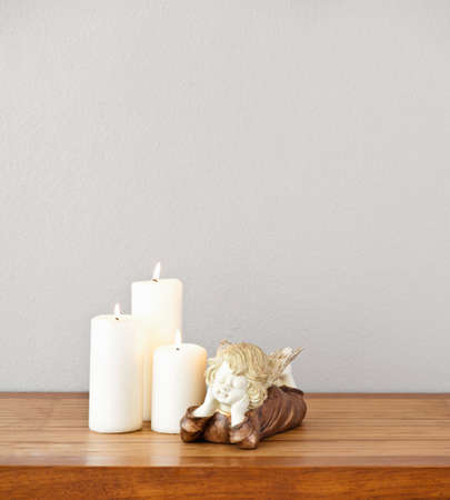 Angel and white candles on side boardの写真素材
