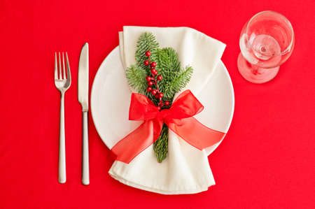 Christmas Dinner table, place setting in red and with wine glassの写真素材