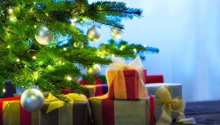 Christmas tree decorated with presents in living roomの写真素材