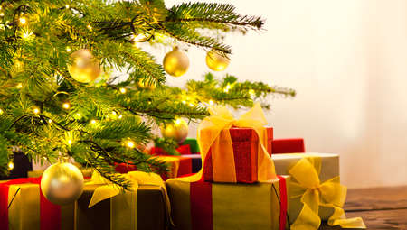 Christmas tree decorated with presents in living roomの写真素材