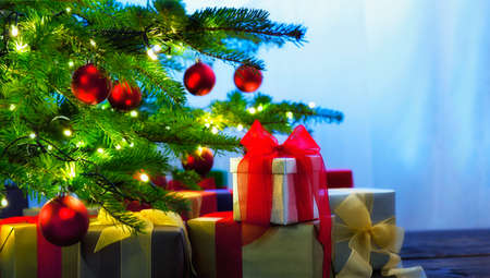 Christmas tree decorated with presents in living roomの写真素材