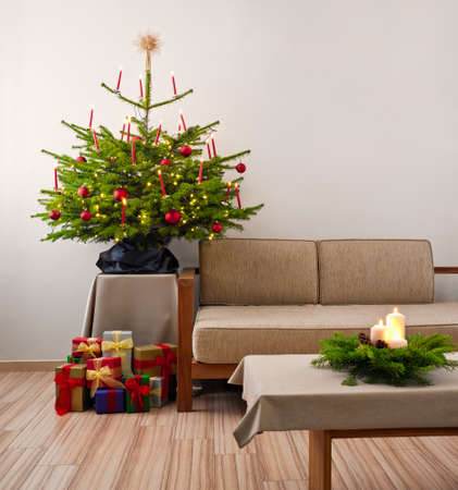 Christmas tree decorated with presents in living roomの写真素材