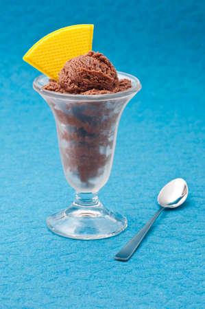 Chocolate ice cream cup with wafer over blue backgroundの写真素材