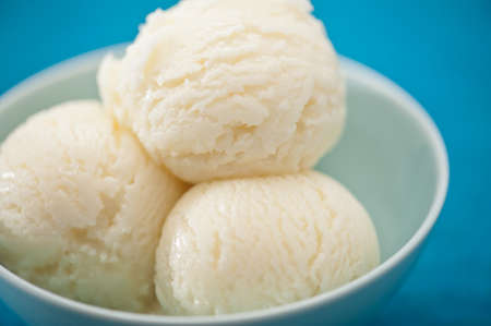 Vanilla ice cream cup over blue backgroundの写真素材