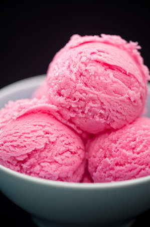 Raspberry ice cream cup over black backgroundの写真素材