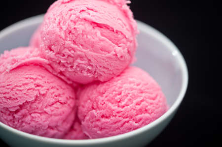 Raspberry ice cream cup over black backgroundの写真素材