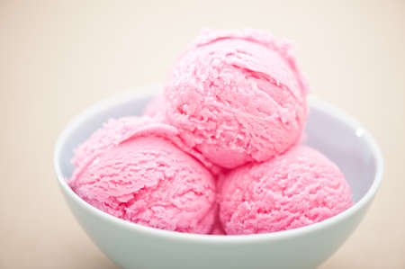 Raspberry ice cream cup over beige backgroundの写真素材
