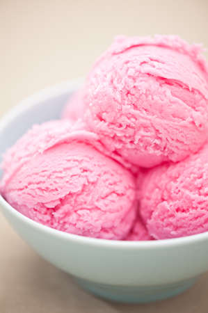 Raspberry ice cream cup over beige backgroundの写真素材