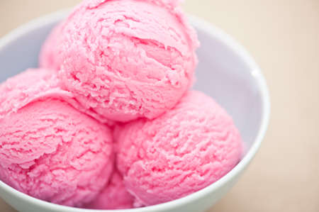 Raspberry ice cream cup over beige backgroundの写真素材