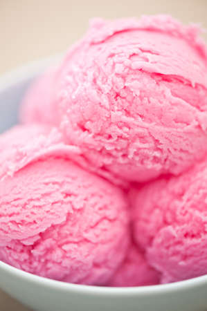Raspberry ice cream cup over beige backgroundの写真素材