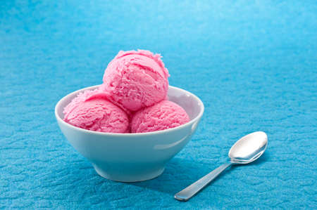 Raspberry ice cream cup over bBLUE backgroundの写真素材