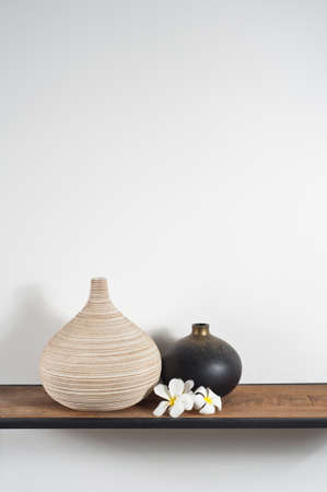 Empty vases decorated with Frangipani flower over side boardの写真素材