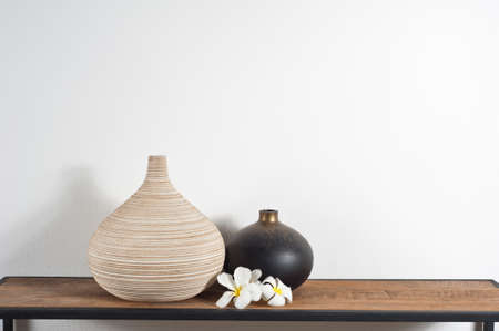 Empty vases decorated with Frangipani flower over side boardの写真素材