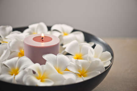 Frangipani flower and candle decoration in a bowlの写真素材