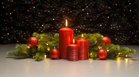 Three red Candles with Christmas tree branches decoratedの写真素材
