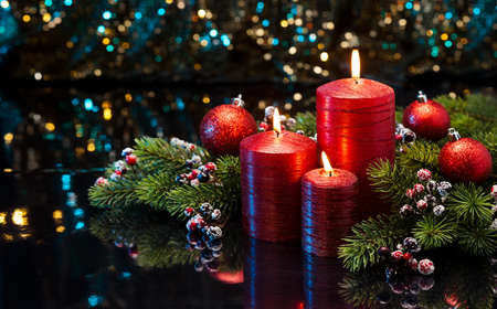 Three red Candles with Christmas tree branches decoratedの写真素材