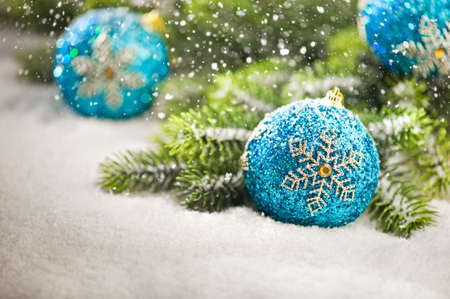 Christmas tree bauble with snow falling and Christmas tree branchesの写真素材
