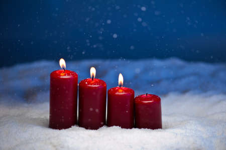 3rd Advent candles in snow and snowfallの写真素材