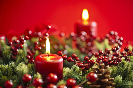 Advent wreath over red background with winter rose and berriesの写真素材