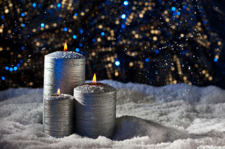 Silver Candles in snow and Christmas settingの写真素材