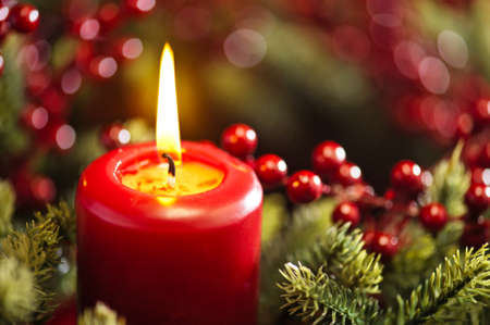 Advent wreath over red background with winter rose and berriesの写真素材