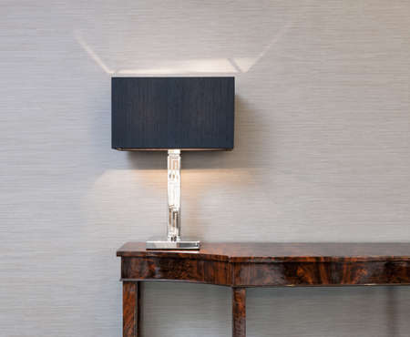 Sideboard in front of a grey wall with table lamp