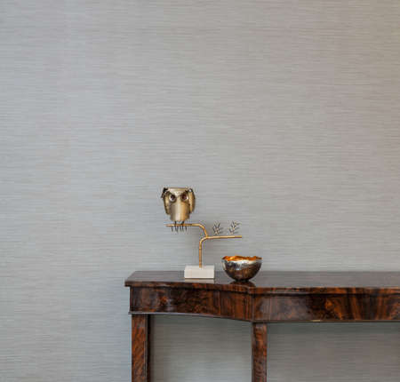 Sideboard in front of a grey wallpaper with art objectsの写真素材