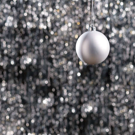 White Christmas bauble over silver glitter backgroundの写真素材