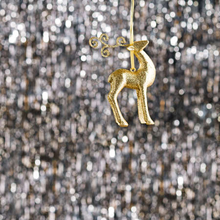 Raindeer christmas ornament over silver glitter backgroundの写真素材