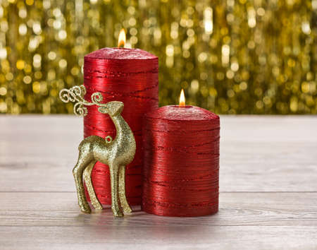 Red candles and rain deer in front of a golden backgroundの写真素材