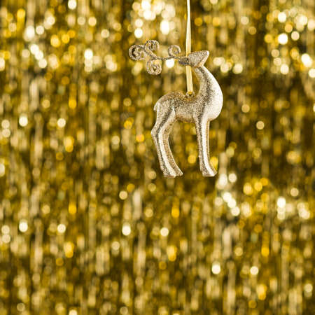 Raindeer christmas ornament over gold glitter の写真素材