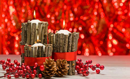 White candles in autumn winter decoration with real branch decorationの写真素材