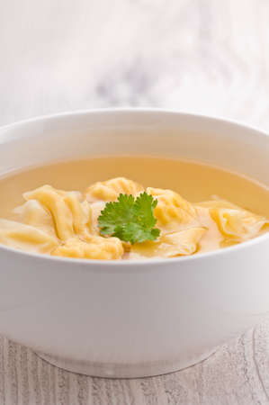 A bowl of Wonton Soup over bright surfaceの写真素材