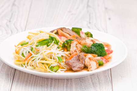 Noodles with Chicken Beef and Crab Stick over bright surfaceの写真素材