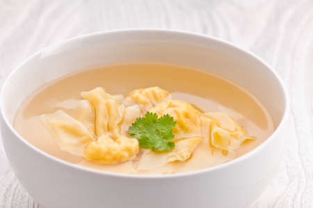 A bowl of Wonton Soup over bright surfaceの写真素材