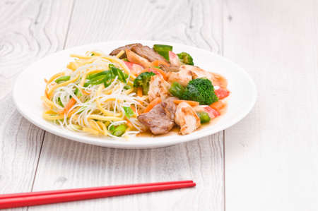 Noodles with Chicken Beef and Crab Stick over bright surfaceの写真素材