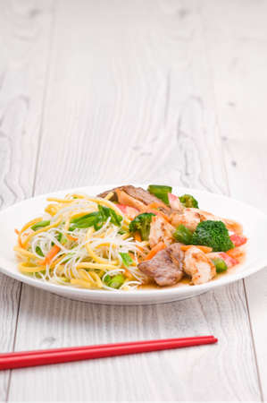 Noodles with Chicken Beef and Crab Stick over bright surfaceの写真素材