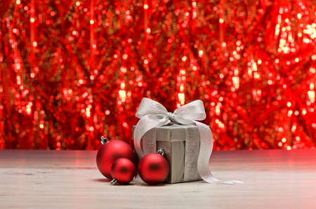 Silver present and baubles in front of a sparkling backgroundの写真素材