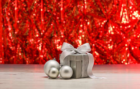 Silver present and baubles in front of a sparkling backgroundの写真素材