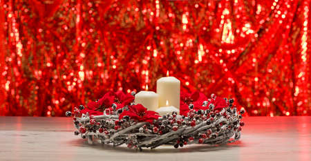 White candles in autumn winter decoration in front of a red backgroundの写真素材