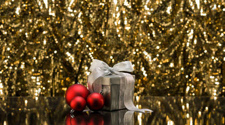 Silver present and baubles in front of a sparkling backgroundの写真素材