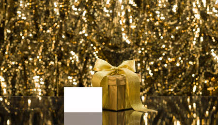 Gold present with place card in front of a sparkling backgroundの写真素材
