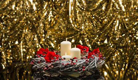 White candles in autumn winter decoration in front of a golden backgroundの写真素材