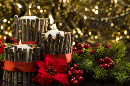 White candles in autumn winter decoration in front of a golden backgroundの写真素材