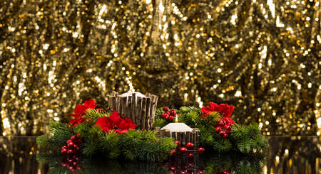 White candles in autumn winter decoration in front of a golden backgroundの写真素材