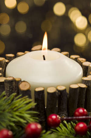 White candles in autumn winter decoration in front of a golden backgroundの写真素材